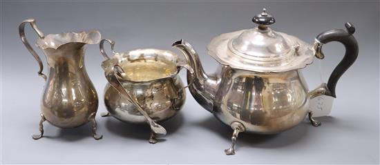 A George V silver three piece silver tea set by Robert Pringle & Sons, London, 1921, and a pair of silver sugar tongs, gross 32 oz.